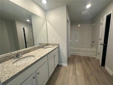 Full bathroom featuring a sink, baseboards, wood finished floors, and tub / shower combination