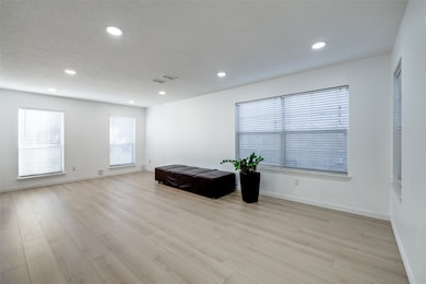 Living/dining area featuring recessed  LED lighting, window blinds and luxury laminate flooring.