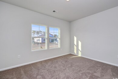 Carpeted spare room featuring baseboards