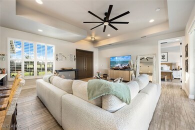 Living room featuring a tray ceiling and ceiling f