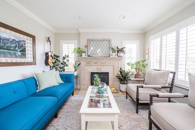 Living room featuring a fireplace, crown molding, and recessed lighting