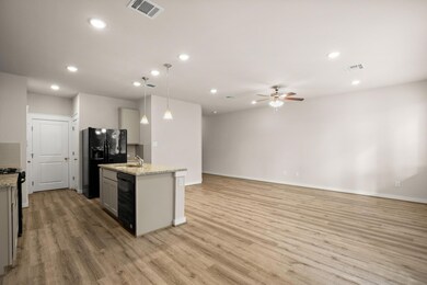 Kitchen with black appliances, light wood-style f