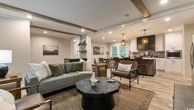 Living room with beam ceiling, recessed lighting, and light wood-style flooring