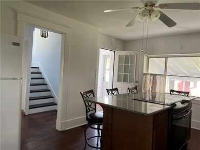 View of kitchen. Steps lead to upper level and doo