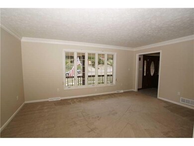 Living Room. Living room view from the dining area illustrates the expansive window and more crown and dentil trim.