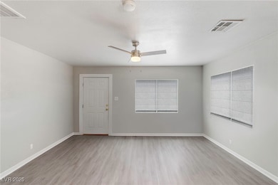 Unfurnished room featuring a textured ceiling, healthy amount of natural light, light wood-type flooring, and ceiling fan