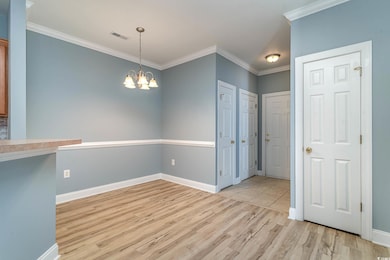 Unfurnished dining area with crown molding, light 