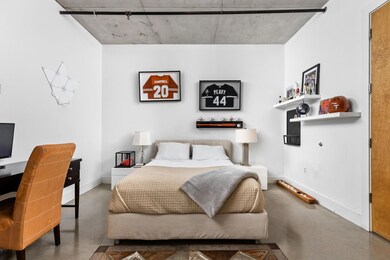 Bedroom with finished concrete flooring, baseboar
