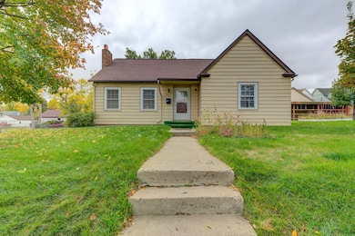 View of front facade with a chimney and a shingled roof