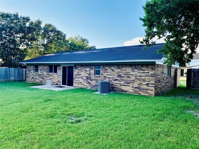 Rear view of house featuring a yard and central ai
