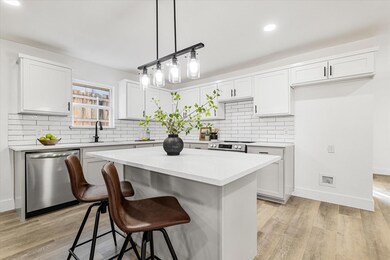 Kitchen with a center island, white cabinets, ligh