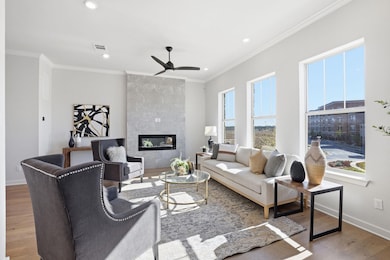 Living room with fireplace, large windows, hardwood flooring, and city views. - 233 John Webster St, Leander, TX 78641