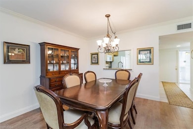 Dining area featuring hardwood / Tile wood like floors, a chandelier, and ornamental molding