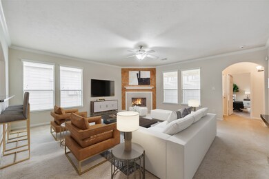 Gather the family and guests together in your lovely living room. Featuring a fireplace with mantel, custom paint, plush carpet, crown molding, ceiling fan with lighting and large windows with privacy blinds.