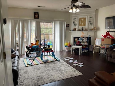 Living room featuring wood-type flooring and a ceiling fan