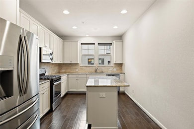 Kitchen featuring dark wood-style flooring, stain