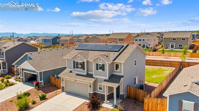 Traditional-style house with a residential view, concrete driveway, a shingled roof, and a fenced backyard