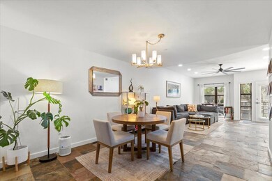 Dining area with recessed lighting, stone tile floors, baseboards, and ceiling fan with notable chandelier