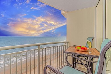 Balcony at dusk featuring view of water and beach