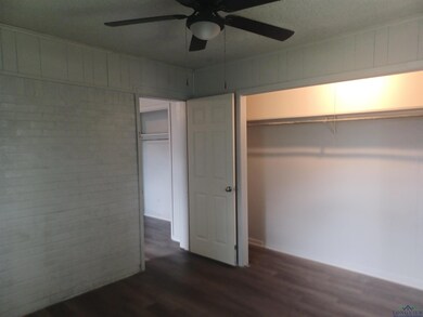 Unfurnished bedroom featuring dark wood-style floors and ceiling fan