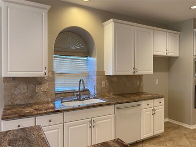 The kitchen window overlooks a large side yard. You get a deep sink and an arched faucet.