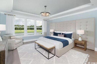 Bedroom with a tray ceiling, a notable chandelier,