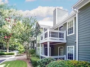 Rear view of property with a balcony and a chimney