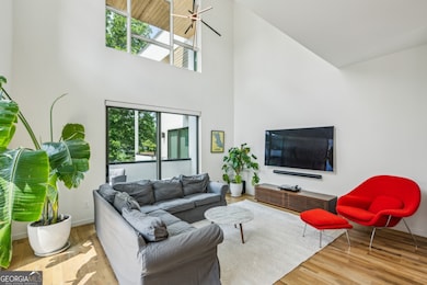 The adjacent Great Room impresses with its Atrium-Style Ceiling, sleek modern accents, and direct access to the Large Rear Porch.