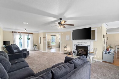 Large living room with ceiling fan, crown molding 