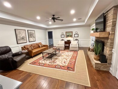 Living room featuring dark wood-style floors, a tr
