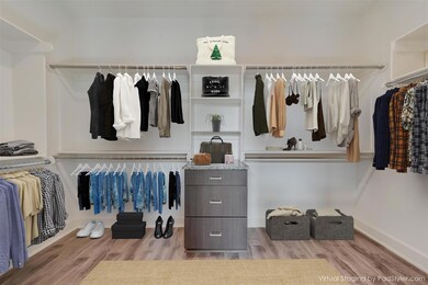 Walk in closet with light wood-type flooring