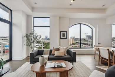 Living area with a tray ceiling, a view of city, and a wealth of natural light