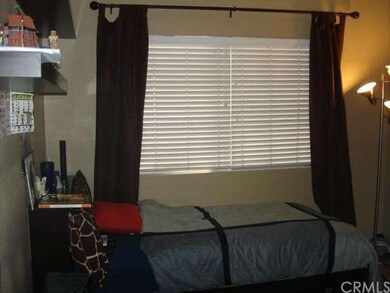 Second bedroom with blinds and side drapes.