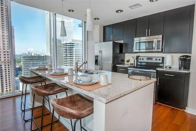 Kitchen with a center island with sink, dark hardw