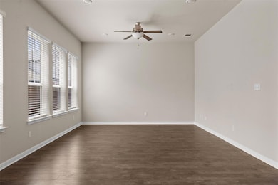Spare room featuring ceiling fan, dark wood-style