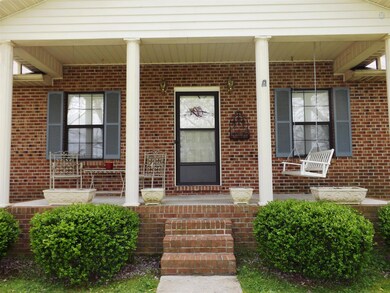 The peaceful front porch welcomes guests with an inviting porch swing and space for table and chairs.