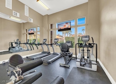 Gym with a towering ceiling and baseboards