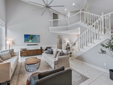 Living room with a towering ceiling, a ceiling fan