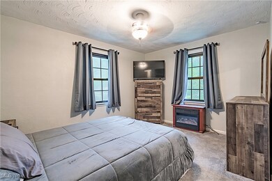 Bedroom with ceiling fan, a textured ceiling, and carpet