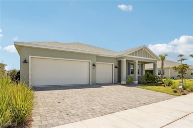 Ranch-style house featuring decorative driveway, an attached garage, stucco siding, and roof with shingles