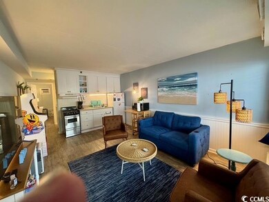 Living area featuring wood finished floors and wainscoting
