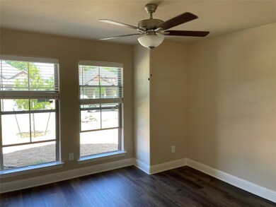 Spare room featuring ceiling fan and dark wood-type flooring