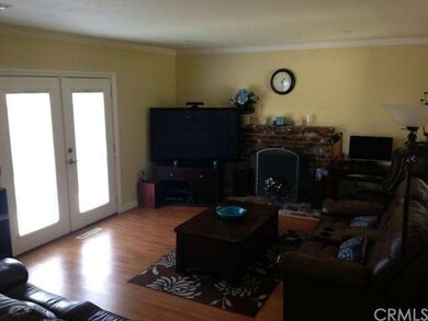 Living room with fireplace; another set of doors o