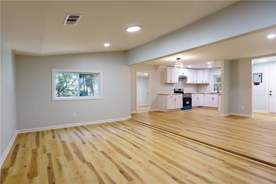 Unfurnished living room featuring light wood-type flooring and recessed lighting