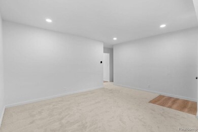 Empty room with recessed lighting and light colored carpet