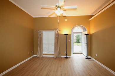 Empty room with ornamental molding, baseboards, a 