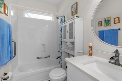 Full bathroom featuring shower / tub combo with curtain, toilet, and vanity