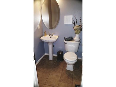 Tiled floors and trim with pedestal sink located b