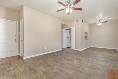 Spare room with visible vents, a ceiling fan, wood