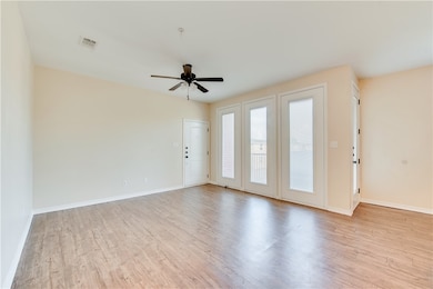 Empty room featuring ceiling fan, baseboards, visi